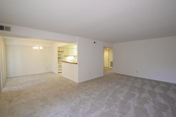 an empty living room with a kitchen in the background  at Charlesgate Apartments, Towson, MD